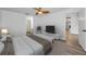 Bright main bedroom featuring a ceiling fan, wood-look floors, and a view into the ensuite bathroom at 2063 Ridgecrest Dr, Dunedin, FL 34698