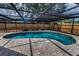 Large in-ground pool with covered patio and wood privacy fence at 2063 Ridgecrest Dr, Dunedin, FL 34698
