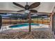 Covered pool area with brick patio, tall wood privacy fence and ceiling fan at 2063 Ridgecrest Dr, Dunedin, FL 34698