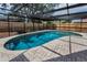 Relaxing screened-in pool with brick paver deck and lush landscaping at 2063 Ridgecrest Dr, Dunedin, FL 34698