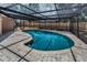 Screened-in pool with brick paver deck offers private outdoor relaxation at 2063 Ridgecrest Dr, Dunedin, FL 34698