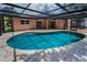 Backyard screened pool with brick paver deck and access to the home's doors at 2063 Ridgecrest Dr, Dunedin, FL 34698