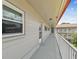 Spacious balcony with white railing, accessible hallway, and view of the surrounding community at 2261 Swedish Dr # 47, Clearwater, FL 33763