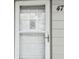 Close-up of the unit's front door with a screen door and decorative hanger at 2261 Swedish Dr # 47, Clearwater, FL 33763