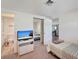 Comfortable bedroom featuring a television and mirrored closet at 260 Venice East Blvd, Venice, FL 34293