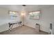 Bright bedroom with two windows and neutral carpet and walls offers a calm, relaxing space at 260 Venice East Blvd, Venice, FL 34293