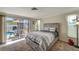 Comfortable bedroom features sliding glass doors to the pool area, carpeting, and natural lighting at 260 Venice East Blvd, Venice, FL 34293