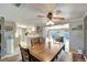 Bright dining area with ceiling fan, wood table and access to the kitchen and enclosed patio with pool view at 260 Venice East Blvd, Venice, FL 34293