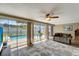 Open living room featuring tile flooring, ceiling fan, and sliding glass doors offering views of the pool area at 260 Venice East Blvd, Venice, FL 34293