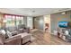 Cozy living room featuring two plush armchairs, wood-look flooring, and an adjacent view of bedroom at 260 Venice East Blvd, Venice, FL 34293