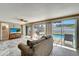 Inviting living room boasts stone tile flooring and sliding glass doors that lead to the screened-in pool area at 260 Venice East Blvd, Venice, FL 34293