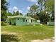 Backyard view of a charming green single story home with beautiful landscaping at 27752 Ravens Brook Rd, Wesley Chapel, FL 33544