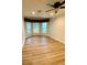 Well-lit bedroom with wood flooring, a ceiling fan, and a bay window at 27752 Ravens Brook Rd, Wesley Chapel, FL 33544
