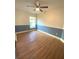 Bedroom with wood-look floors, ceiling fan and natural light at 27752 Ravens Brook Rd, Wesley Chapel, FL 33544