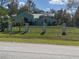 Single-story home behind a fence and pillars surrounded by grass at 27752 Ravens Brook Rd, Wesley Chapel, FL 33544