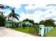 Well-maintained single-story home is surrounded by lush lawn, mature trees, and a gated brick driveway at 27752 Ravens Brook Rd, Wesley Chapel, FL 33544