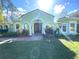 Beautiful single-story home boasts a lush front lawn, arched entryway with double doors, and verdant landscaping at 27752 Ravens Brook Rd, Wesley Chapel, FL 33544
