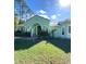 Charming single-story home features a lush front lawn and elegant arched entryway with double doors at 27752 Ravens Brook Rd, Wesley Chapel, FL 33544