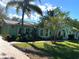Attractive single-story home with tile roof, verdant landscaping, and a brick driveway nestled beneath mature trees at 27752 Ravens Brook Rd, Wesley Chapel, FL 33544