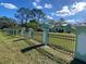 Exterior view of home with fence and pillars surrounded by grass at 27752 Ravens Brook Rd, Wesley Chapel, FL 33544
