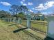 Exterior view of home with fence and pillars surrounded by grass at 27752 Ravens Brook Rd, Wesley Chapel, FL 33544
