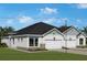 Exterior elevation with an attached two car garage, black roof and manicured lawn at 2824 Marrakesh Ln, Sarasota, FL 34234