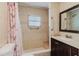 Bright bathroom featuring tiled shower with grab bars, a small window, and a vanity at 2825 N Taliaferro N Ave, Tampa, FL 33602