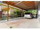 View of the covered carport next to the house and its lush landscaping at 2825 N Taliaferro N Ave, Tampa, FL 33602