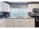 Modern kitchen with granite countertops, white cabinets, and stainless steel appliances at 2825 N Taliaferro N Ave, Tampa, FL 33602