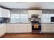 Modern kitchen with granite countertops, white cabinets, stainless appliances, and stylish backsplash at 2825 N Taliaferro N Ave, Tampa, FL 33602