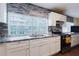 Modern kitchen with granite countertops, white cabinets, and stainless steel appliances at 2825 N Taliaferro N Ave, Tampa, FL 33602