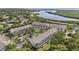 Aerial view showcases condo community with pool and verdant landscaping near a bay at 3147 Oyster Bayou Way, Clearwater, FL 33759