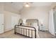 This bedroom has neutral walls, a ceiling fan, balcony, and a black iron bed frame at 3147 Oyster Bayou Way, Clearwater, FL 33759