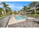 Community pool with brick pavers, surrounded by palm trees and seating area at 3147 Oyster Bayou Way, Clearwater, FL 33759