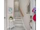 Bright entryway with a staircase featuring painted wood, a decorative mirror, and a charming side table at 3147 Oyster Bayou Way, Clearwater, FL 33759