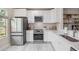 Modern kitchen with stainless steel appliances, white cabinets, light countertops, and hardwood floors at 3147 Oyster Bayou Way, Clearwater, FL 33759