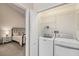 Bright laundry area with washer, dryer, and shelving next to a bedroom at 3147 Oyster Bayou Way, Clearwater, FL 33759
