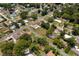 Wide aerial view of neighborhood with mature trees, various homes, and tree-lined streets at 39243 6Th Ave, Zephyrhills, FL 33542