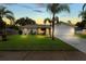 Charming single-story home featuring a well-manicured lawn, mature palm trees, and a two-car garage at 39243 6Th Ave, Zephyrhills, FL 33542