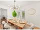 Dining room with modern lighting, table setting for six, and backyard access at 4012 W Pearl Ave, Tampa, FL 33611