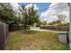 Large grassy backyard with a mature tree, bordered by a wooden fence and a shed at 4301 5Th N Ave, St Petersburg, FL 33713