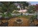 Beautiful backyard with stone fire pit and ample seating, illuminated with string lights for enchanting evenings at 4609 S Lois Ave, Tampa, FL 33611