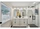 Modern bathroom featuring a double vanity, sleek mirrors, a glass-enclosed shower with stylish tile work and black hardware at 4609 S Lois Ave, Tampa, FL 33611