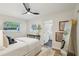 Calm bedroom featuring a neutral palette, ceiling fan, and view to the bathroom entrance at 4609 S Lois Ave, Tampa, FL 33611