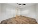 Bedroom with wood-look floors, a modern ceiling fan, closet with sliding doors, and an open door to another room at 4609 S Lois Ave, Tampa, FL 33611