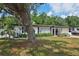 Charming single story house with manicured lawn, mature tree, and lovely curb appeal on a sunny day at 4609 S Lois Ave, Tampa, FL 33611