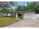 Well-maintained single-story home featuring a landscaped front yard with a driveway at 4609 S Lois Ave, Tampa, FL 33611