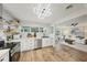 Well-lit kitchen with stainless steel appliances, white cabinetry, decorative backsplash, and adjoined living space at 4609 S Lois Ave, Tampa, FL 33611