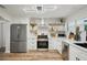 Modern kitchen featuring stainless steel appliances, white cabinetry, floating wood shelves, and a geometric backsplash at 4609 S Lois Ave, Tampa, FL 33611