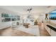 Bright living room with large windows, white furniture, and wood-look flooring at 4609 S Lois Ave, Tampa, FL 33611